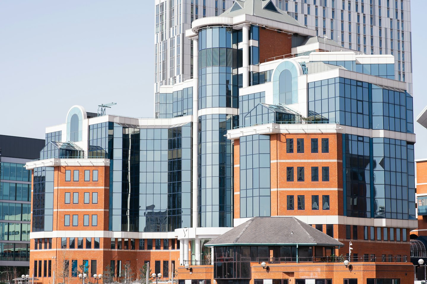 Edificios de oficinas modernos con fachadas de vidrio azul y ladrillo rojo.