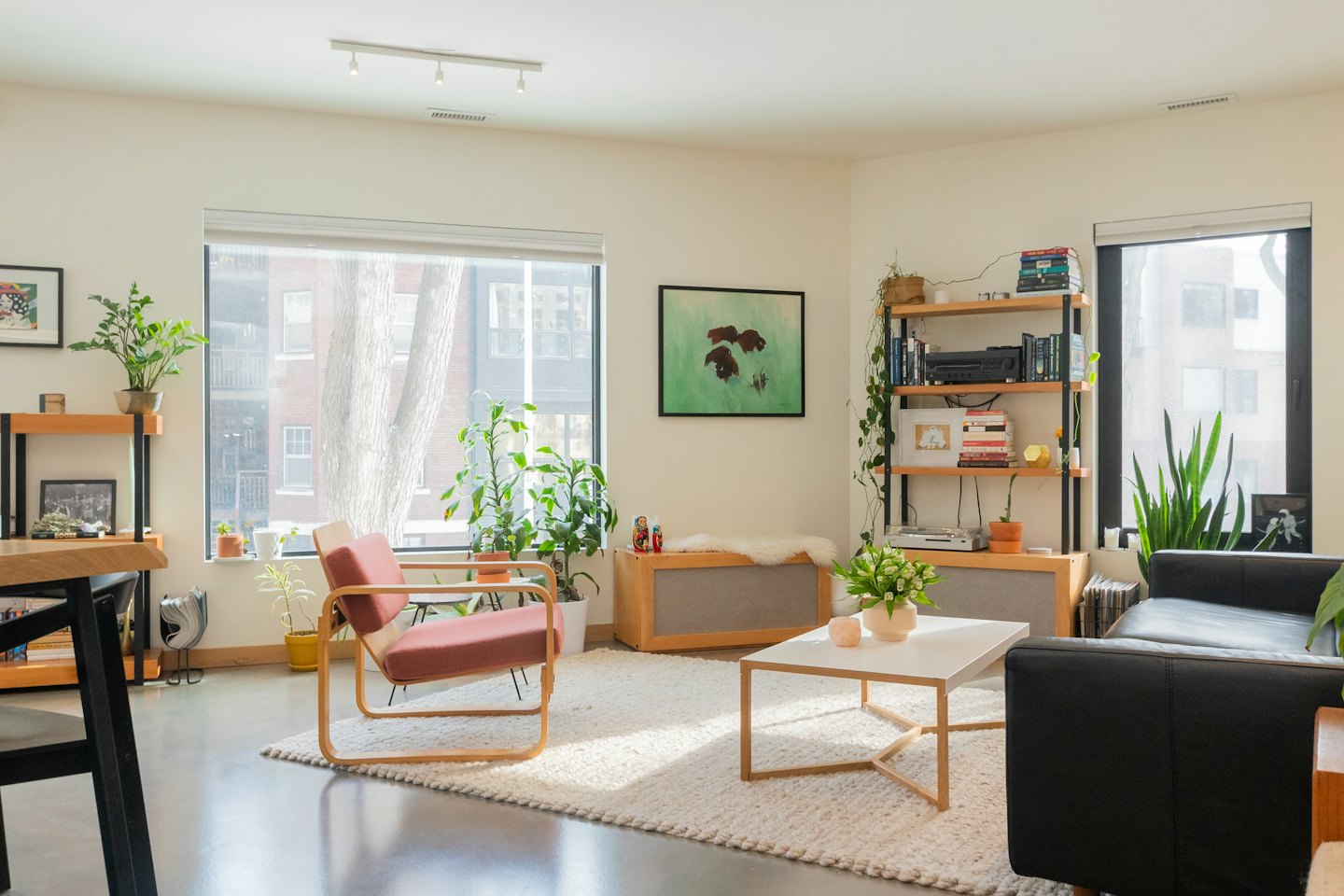 Sala de estar moderna con sillón rojo y plantas.